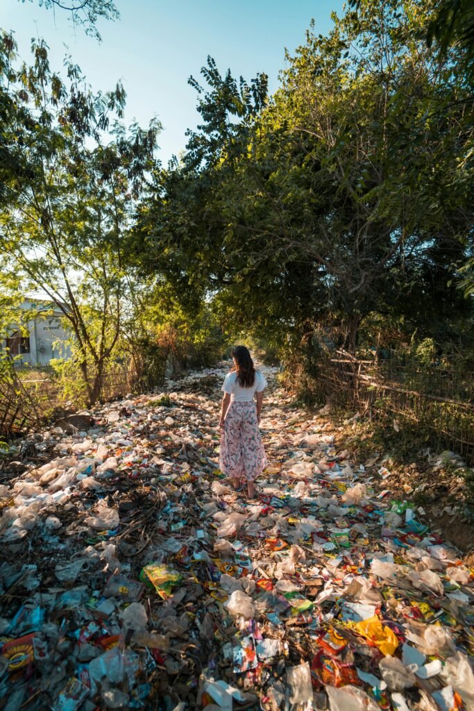 pexels-photo-2583835-2583835-1 A woman walks through a forested area littered with plastic waste in Myanmar.